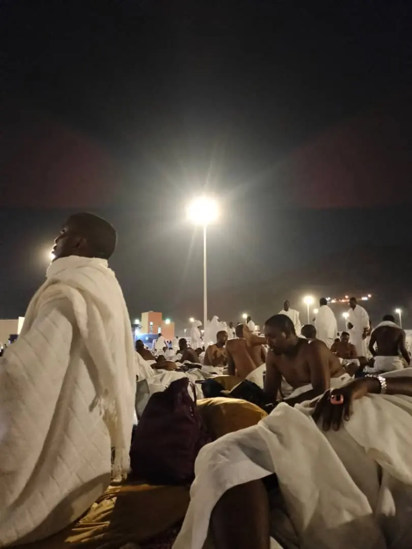 Pilgrims in ihram resting outdoors at night