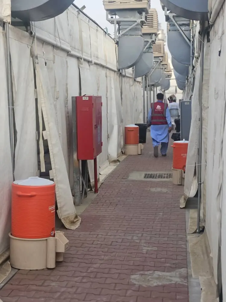 Walkway between air-conditioned pilgrim tents at Mina with water coolers